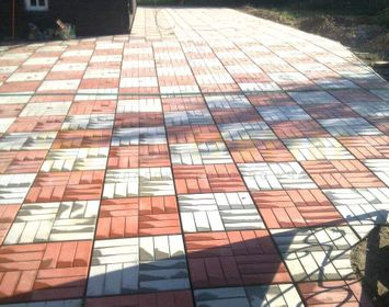 Участок около дома мощенная тротуарной плиткой 12 кирпичей с сочетанием цветов серого и красного цвета в шахматном порядке