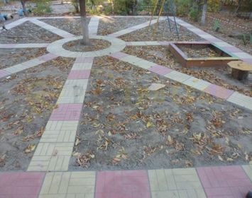 Красиво обустроенная детская площадка дорожками из тротуарной плитки 12 кирпичей с сочетанием цветов красный и серый